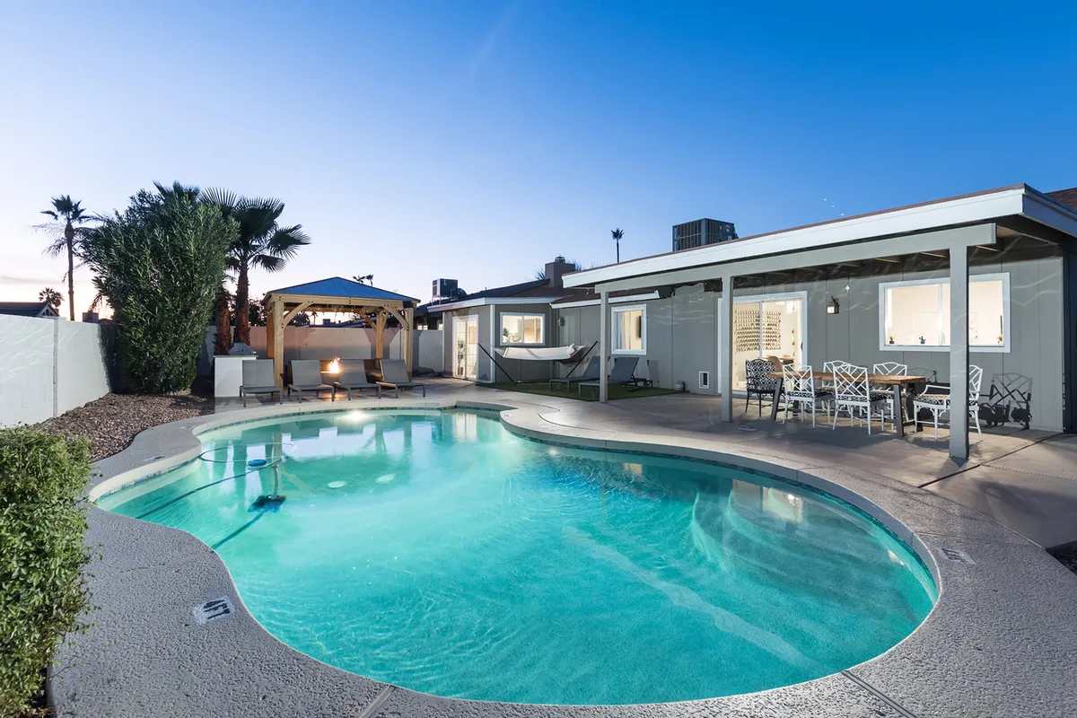 The hero image showcases a sparkling swimming pool surrounded by inviting lounge chairs, a stylish outdoor seating area under a gazebo, and warm sunset lighting that casts a golden glow over the backyard. The scene exudes tranquility and encourages relaxation or social gatherings, with plenty of space for guests to unwind or dine al fresco.